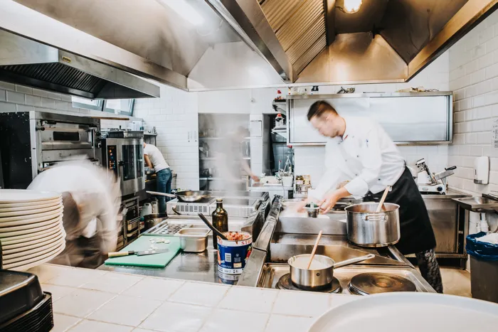 Zespół kucharzy w restauracyjnej kuchni